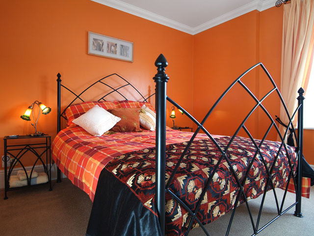 An exquisite bed is placed centrally in a bright bedroom